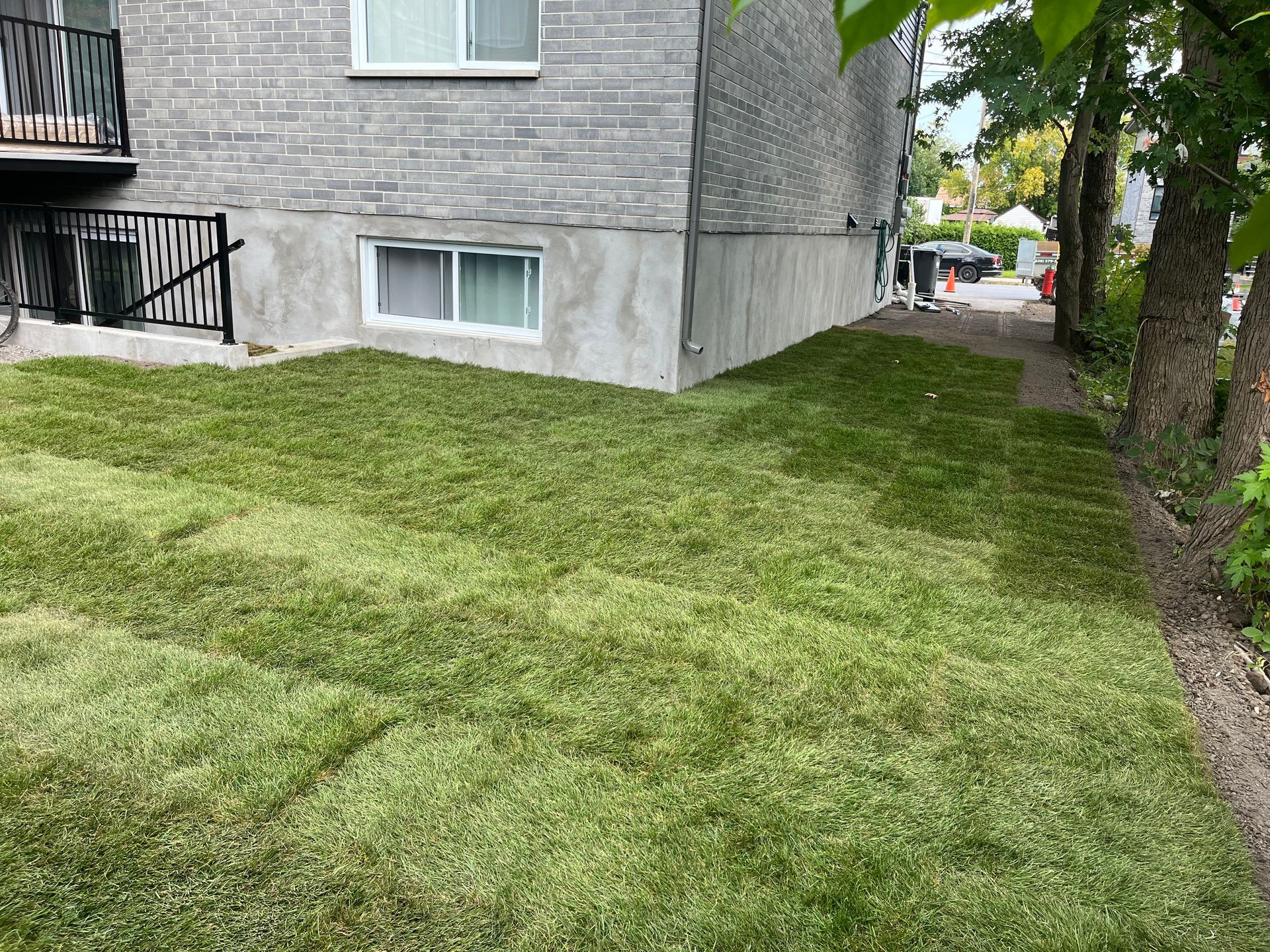 A lush green lawn in front of a brick building.