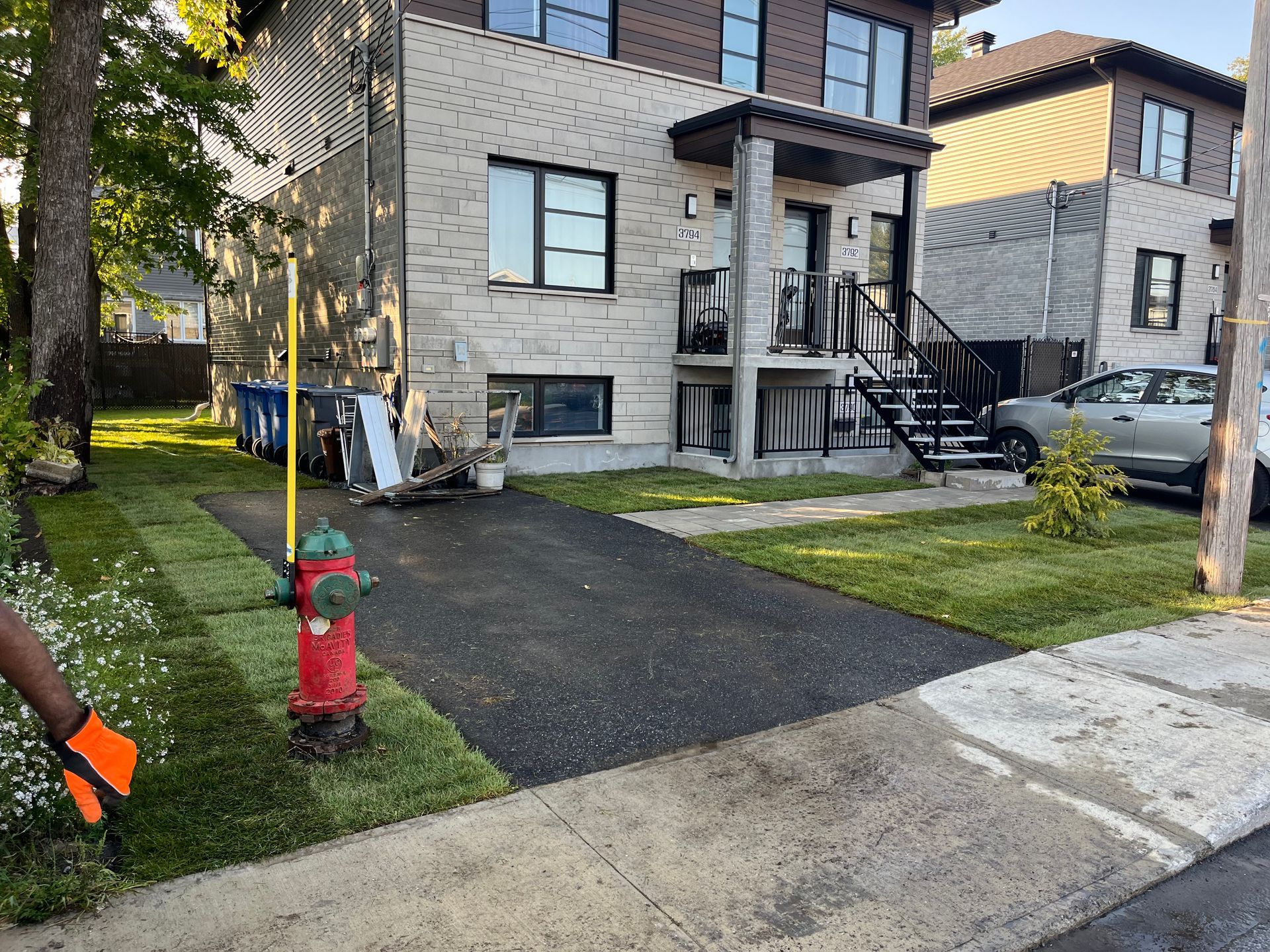 A red fire hydrant is in front of a house.