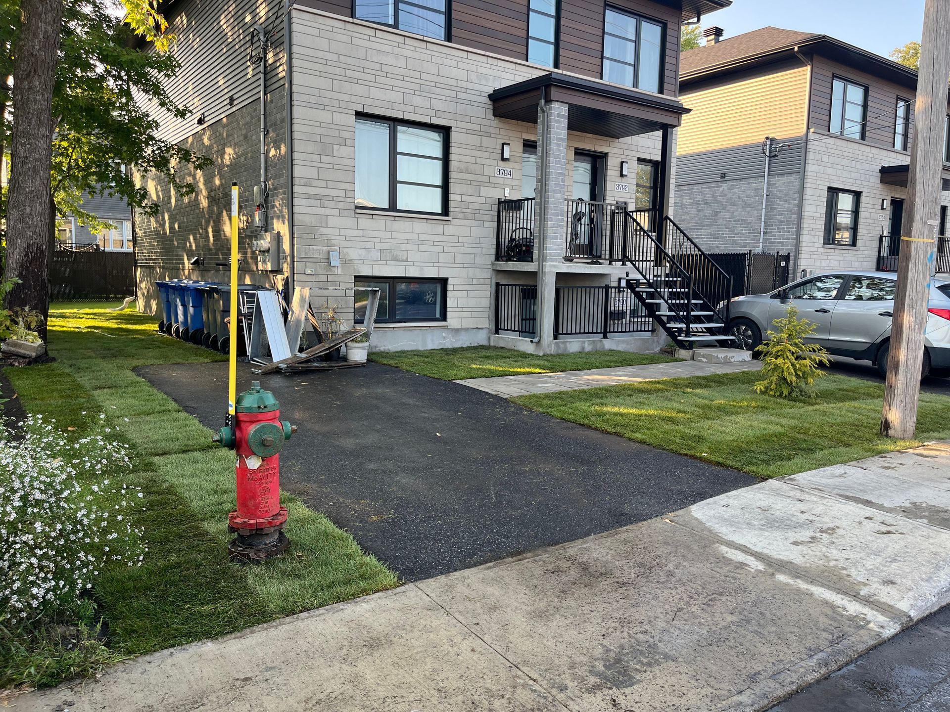 A red fire hydrant is in front of a house.