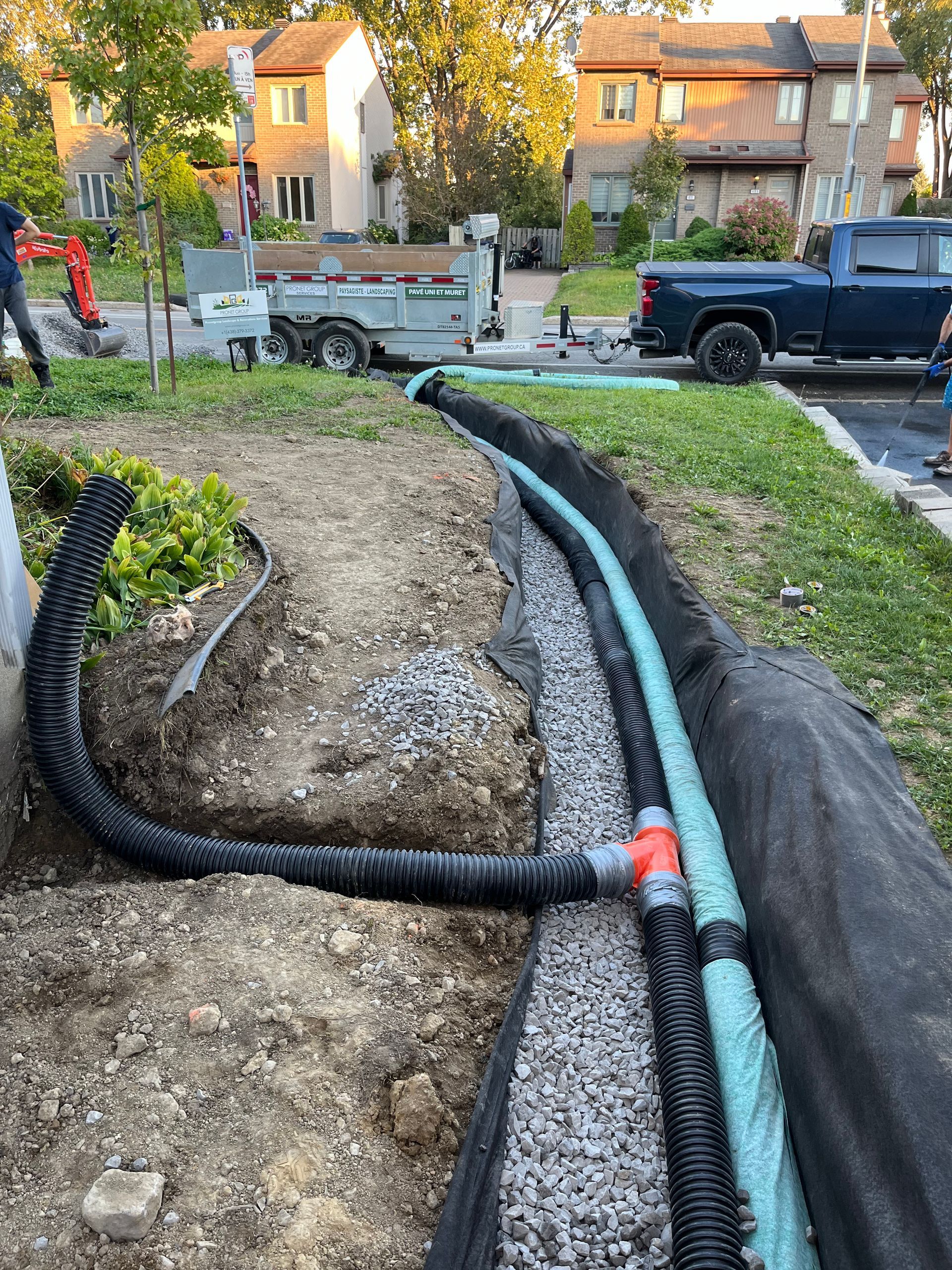 A hose is being installed in the ground next to a truck.