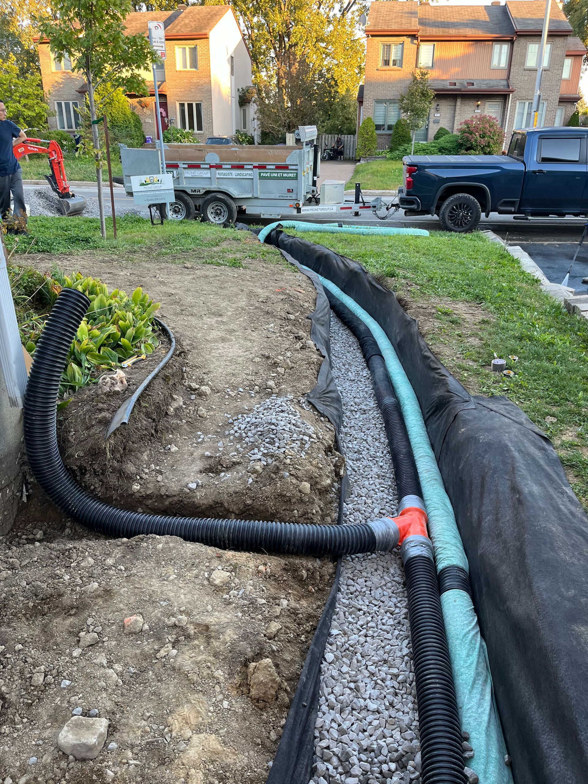 A black truck is parked next to a hose in the dirt.