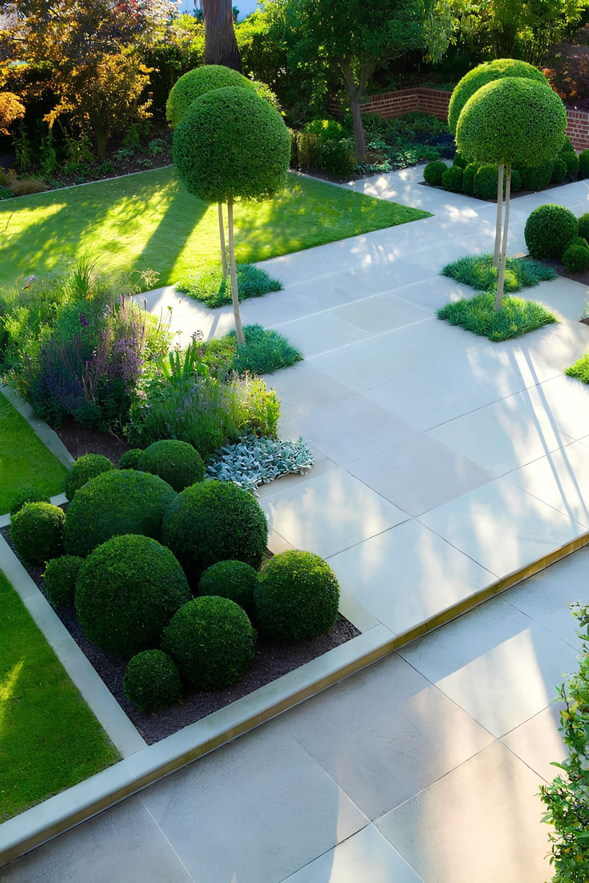 A lush green garden with a concrete walkway surrounded by trees and bushes