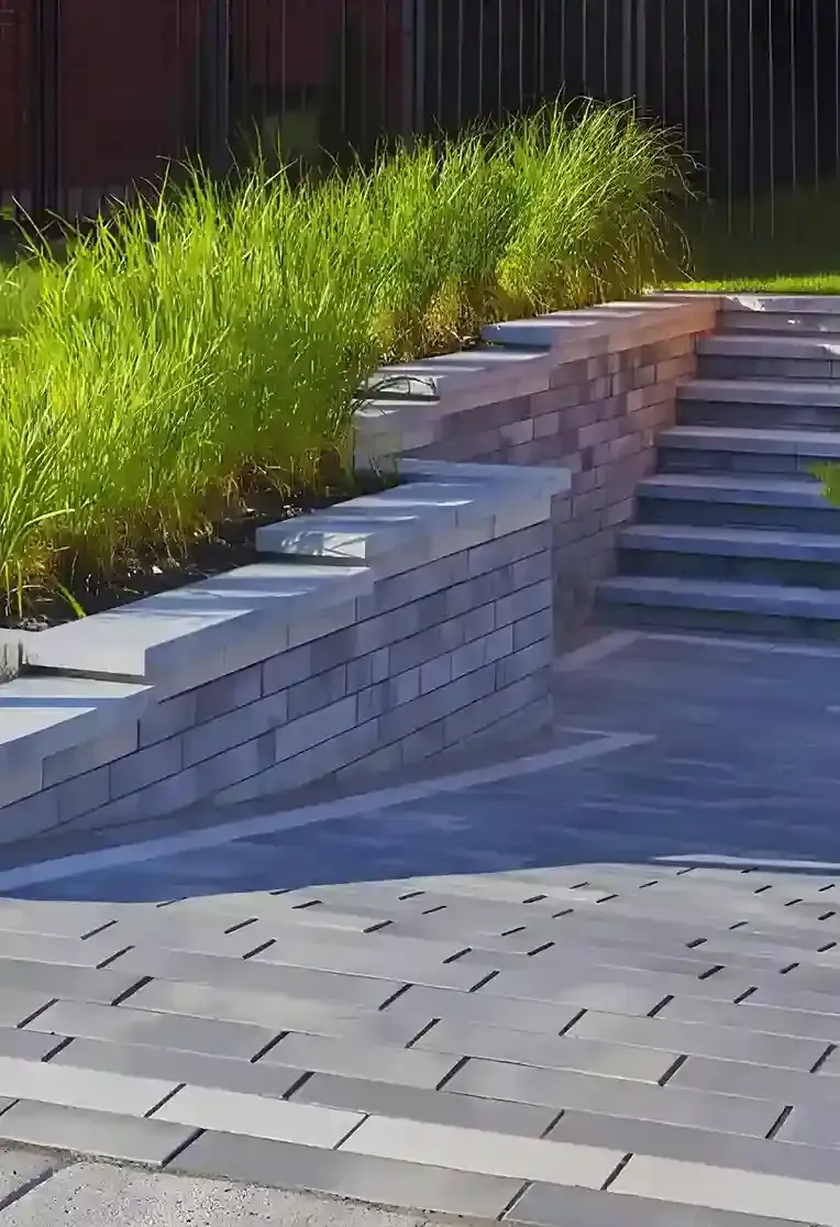 A brick wall with stairs leading up to it in a garden.