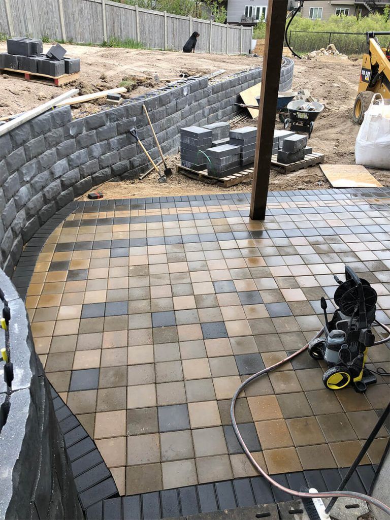 A patio is being built with bricks and a hose.