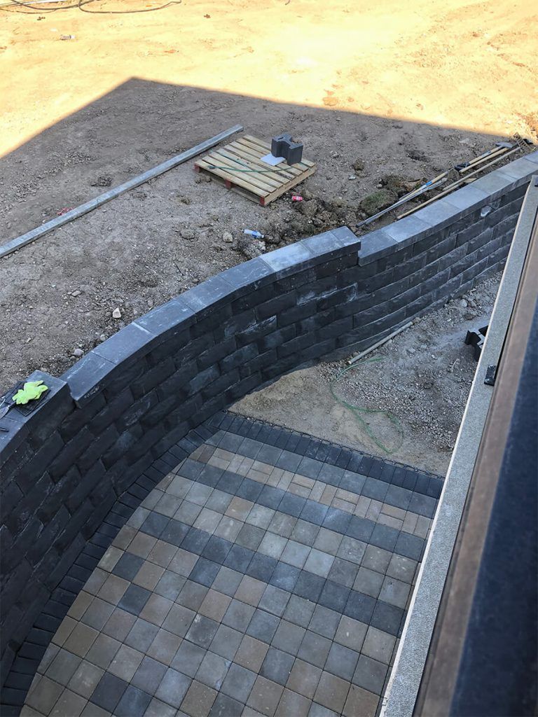 A brick wall is being built next to a set of stairs.