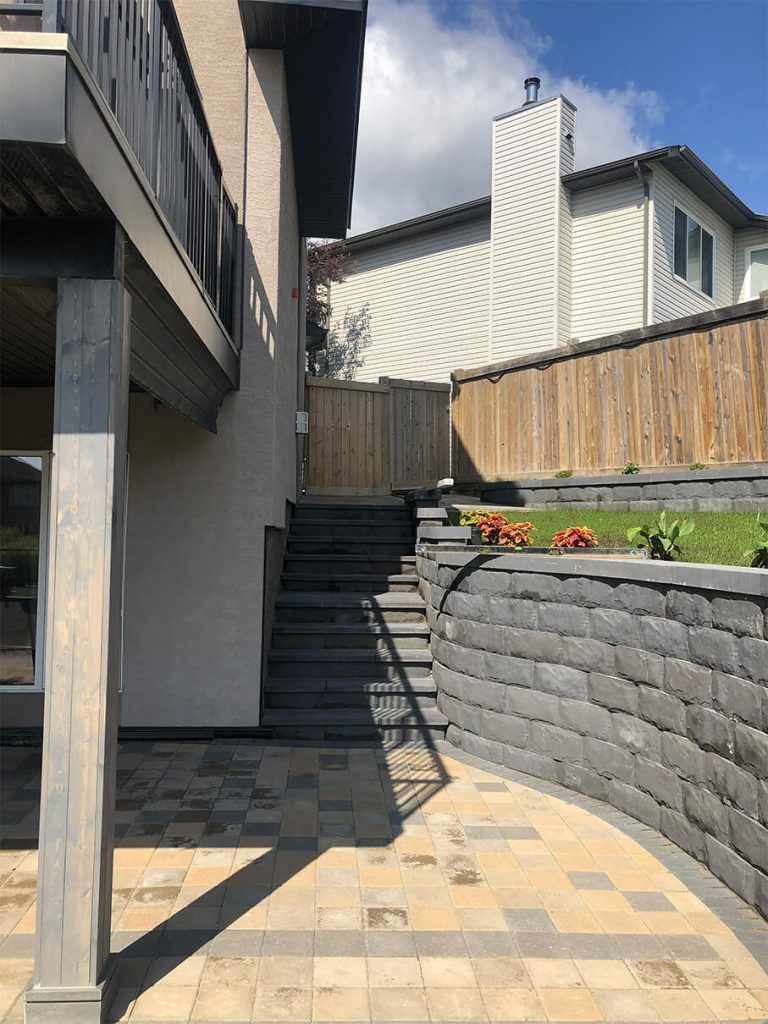 There are stairs leading up to the backyard of a house.