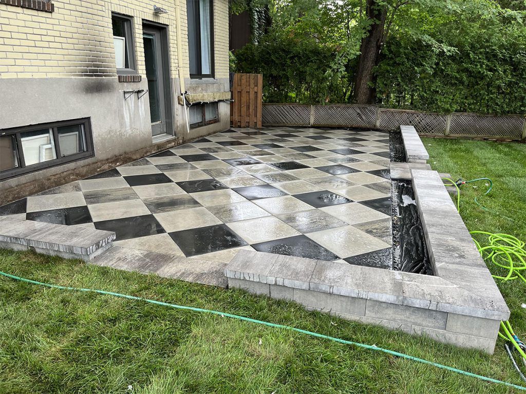 A black and white checkered patio in front of a house.