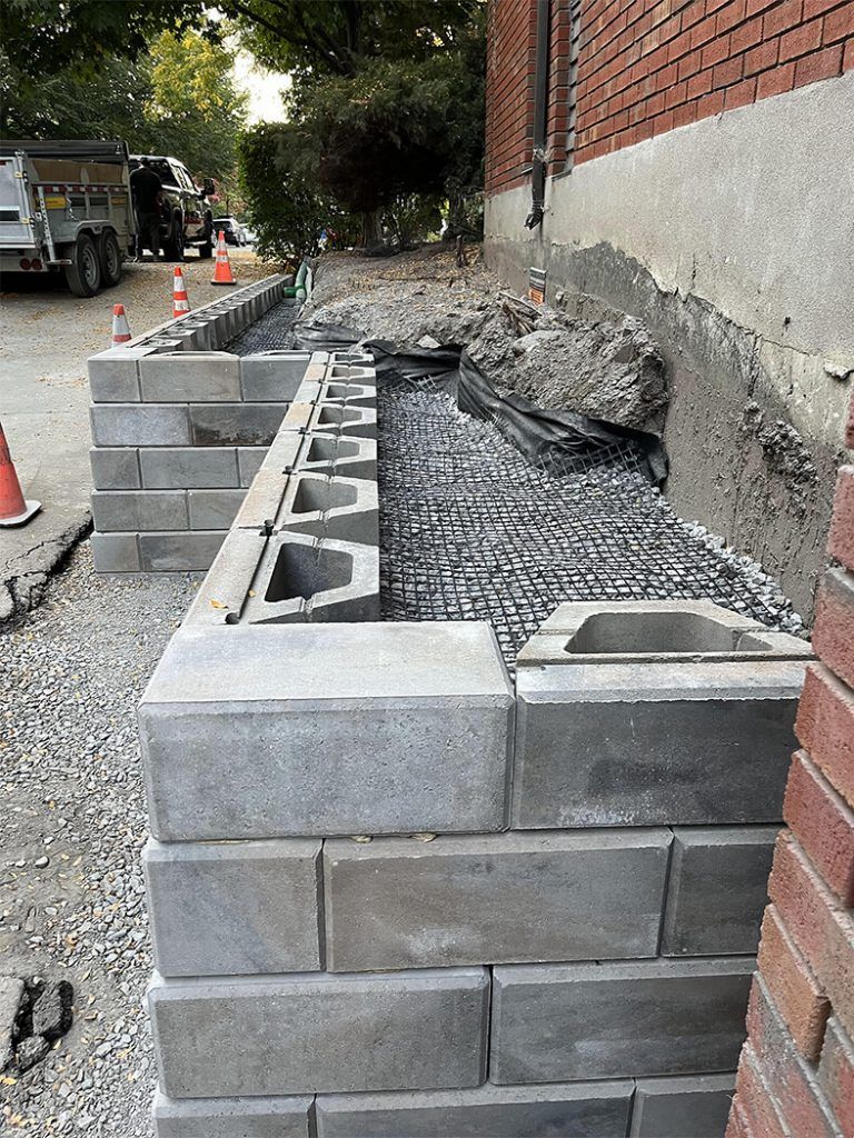 A brick wall is being built next to a brick building.