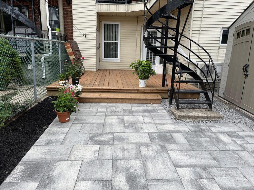 There is a spiral staircase in the backyard of a house.
