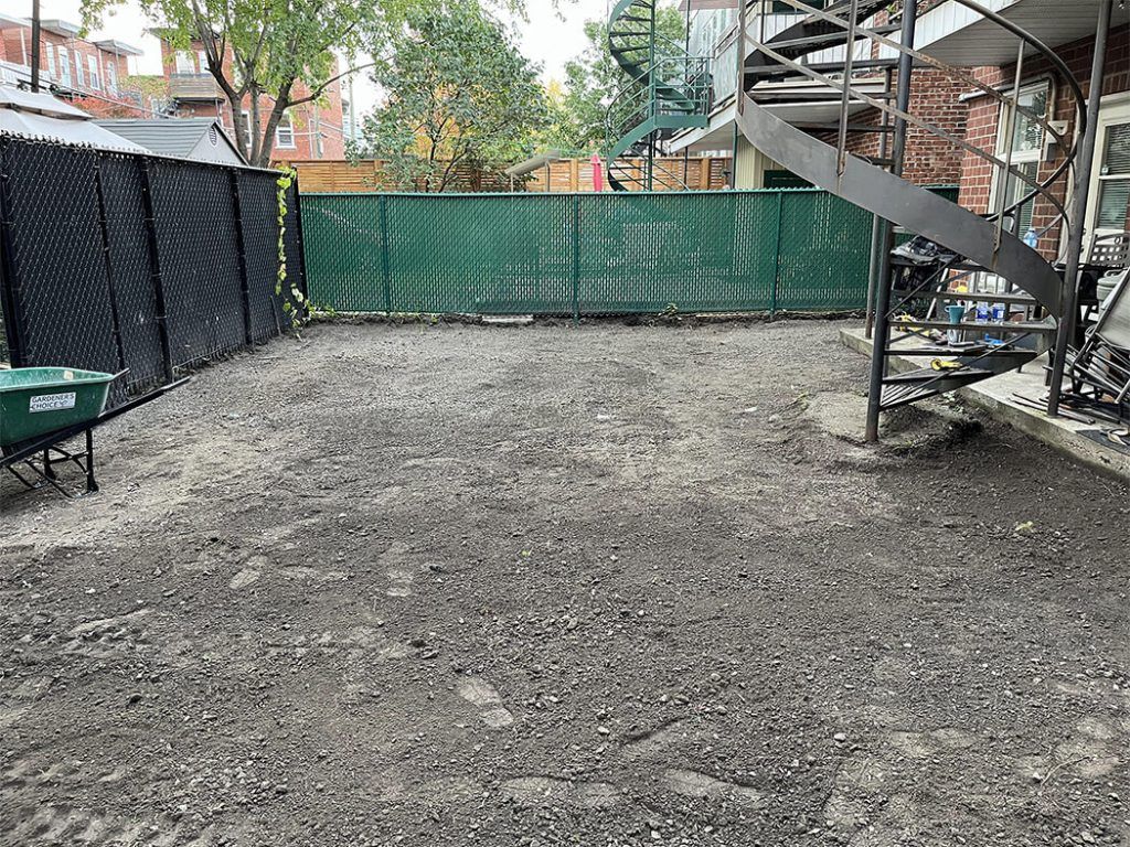 There is a spiral staircase in the backyard of a house.