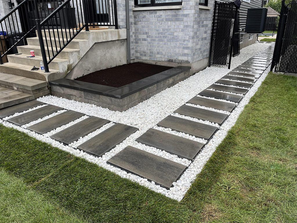 A walkway leading to a house with stairs and gravel.