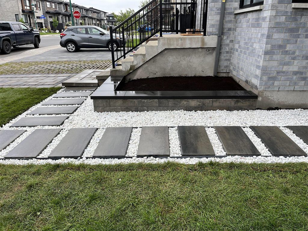 A house with stairs and a walkway in front of it.