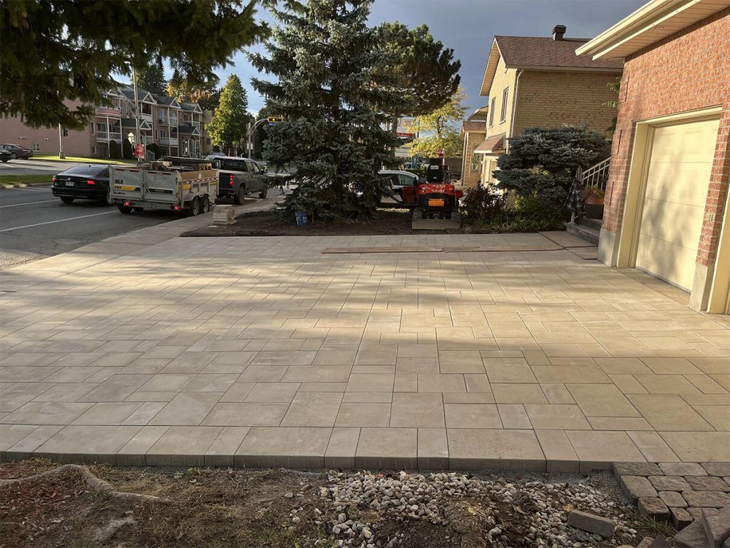 A driveway is being built in front of a brick house.