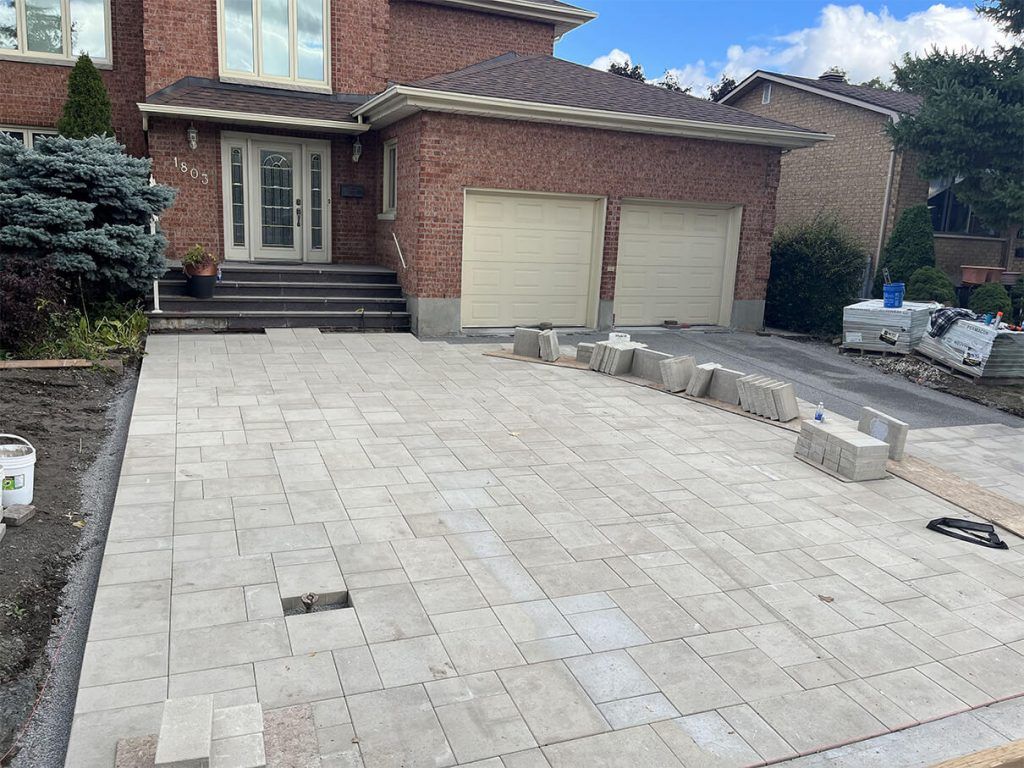 A driveway is being built in front of a brick house.