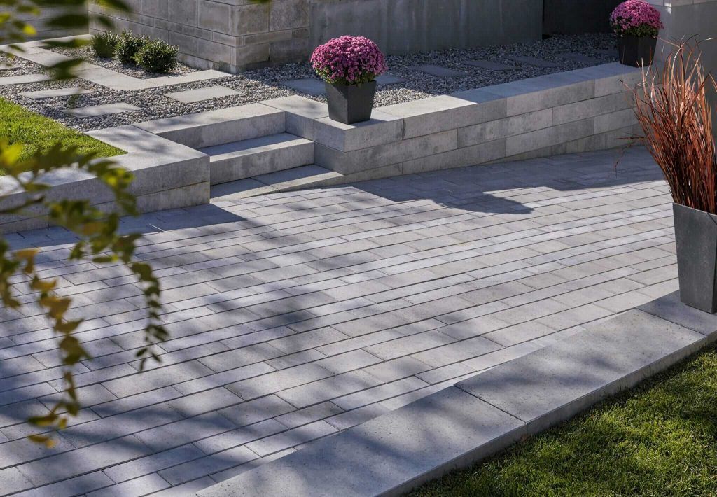 A patio with flowers in pots on the side of it.
