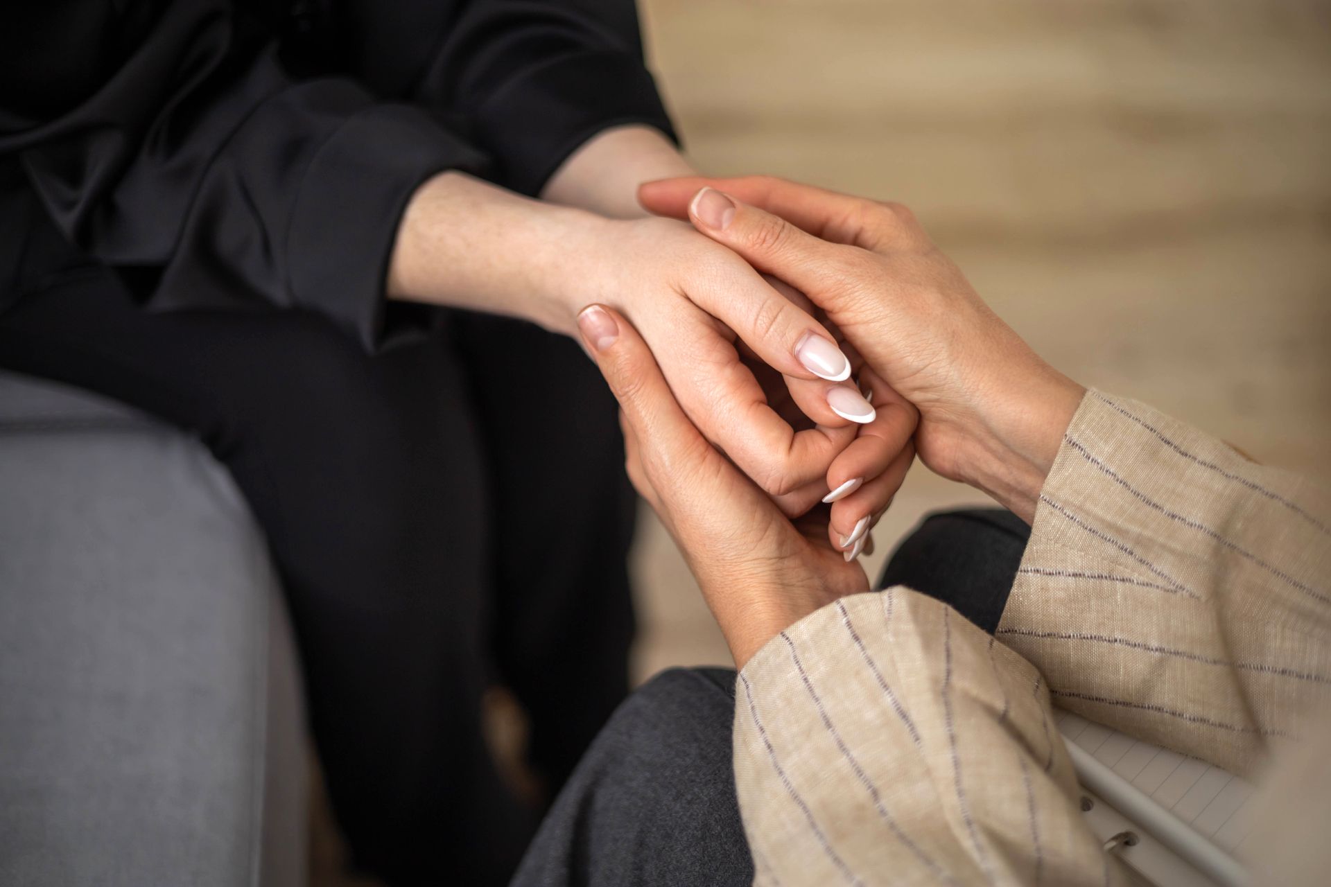 A man and a woman are holding hands over a wooden table.