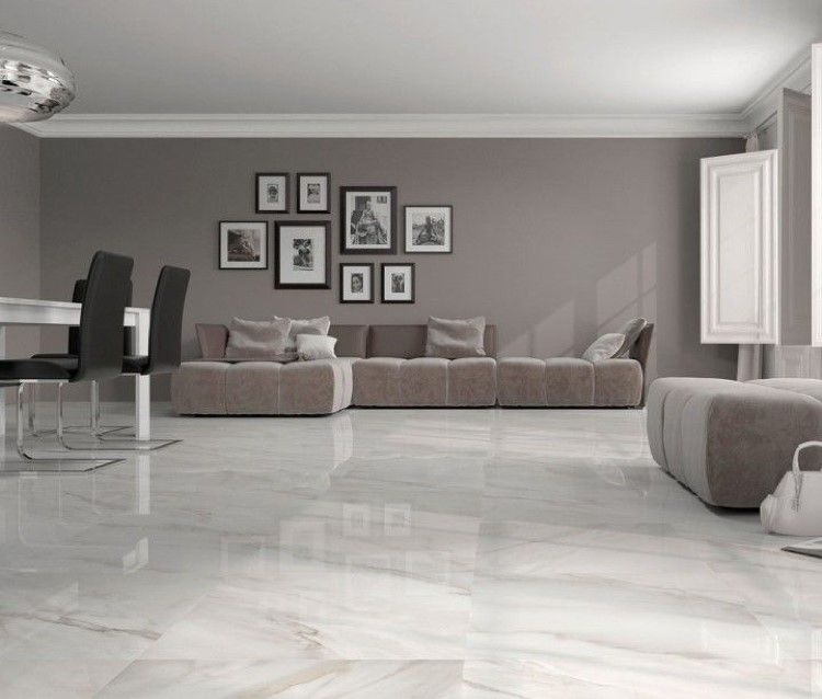 Living room with glossy white tile floor, taupe walls, and a large sectional sofa.