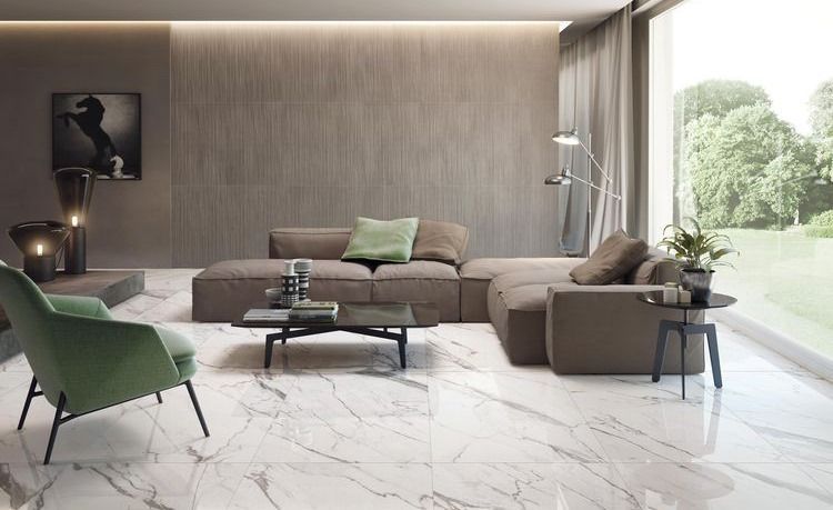 Modern living room with marble flooring, grey sofa, green chair, and large window overlooking a garden.