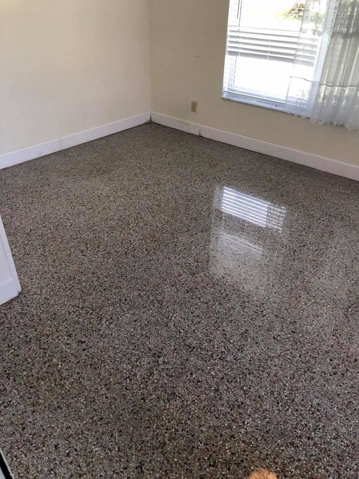 Room with polished terrazzo floor, white walls, and a window with blinds.