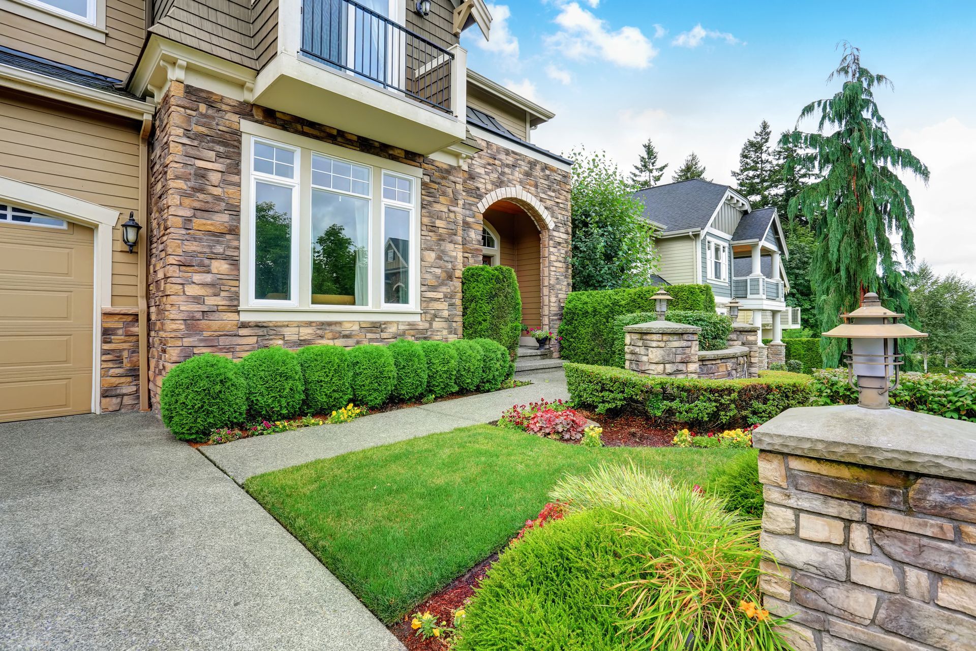 Beautiful curb appeal of American house with stone trim and perfectly trimmed shrubs. Beautiful curb appeal of American house with stone trim and perfectly trimmed shrubs.