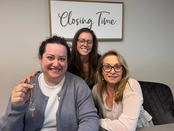 A large building with a lot of windows is surrounded by grass and trees