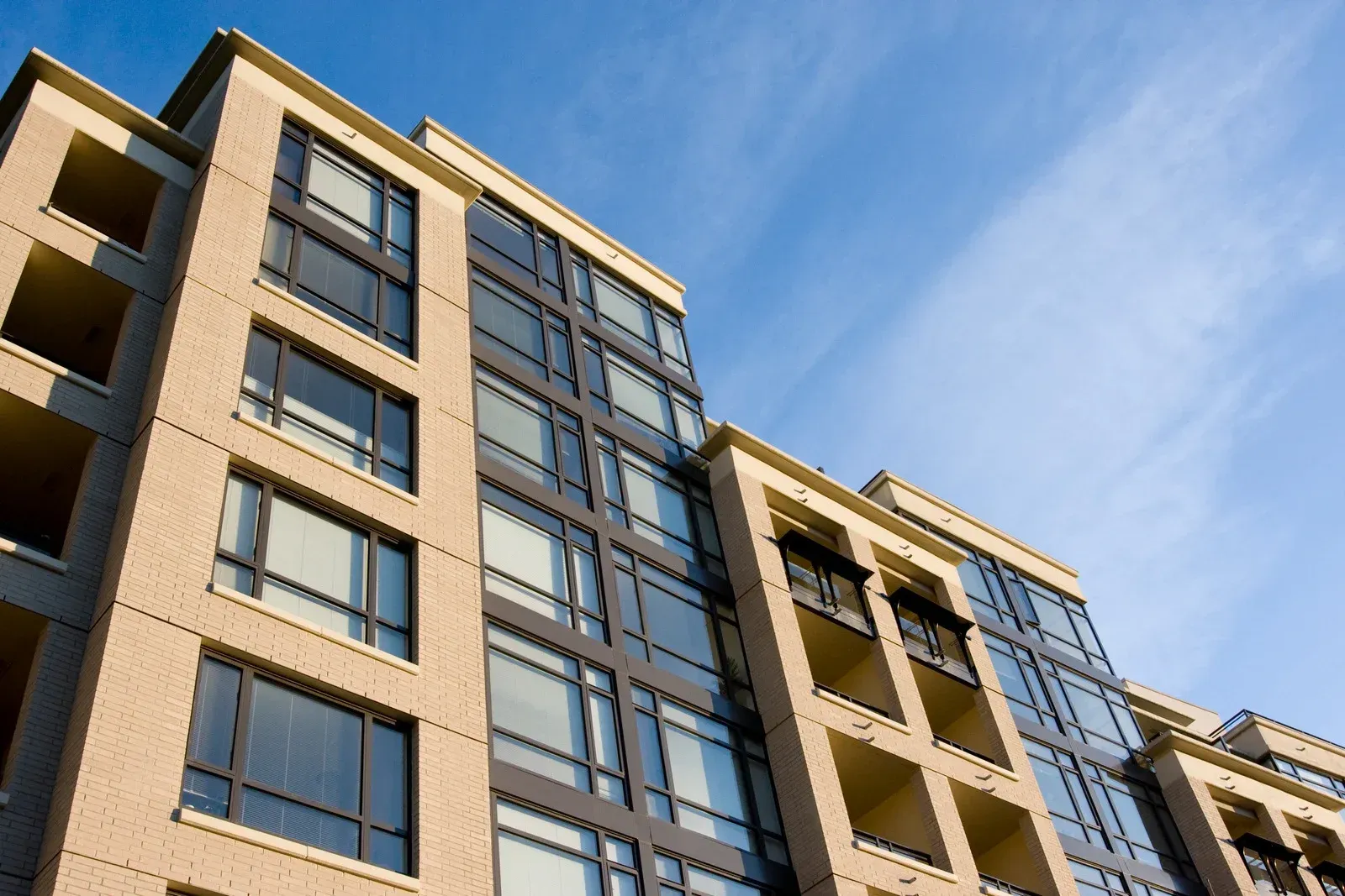 A tall building with lots of windows against a blue sky