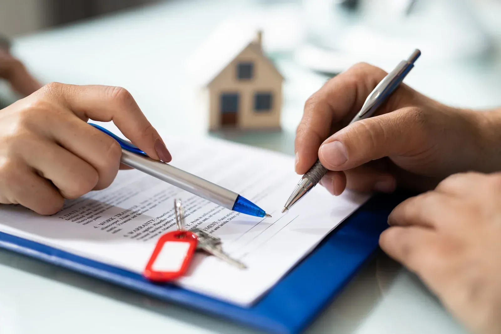 A person is writing on a piece of paper with a pen.