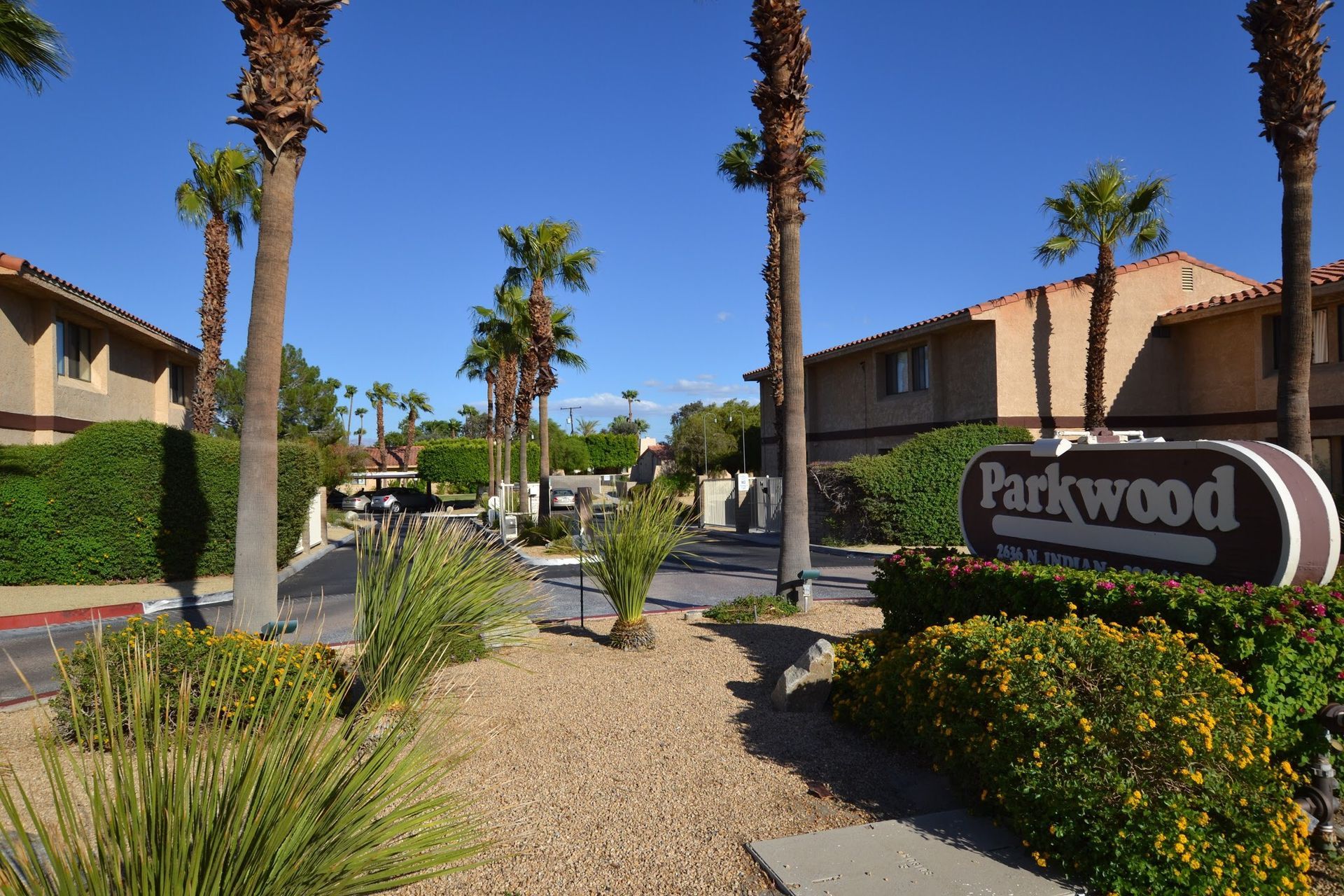 Parkwood sign is surrounded by palm trees and bushes