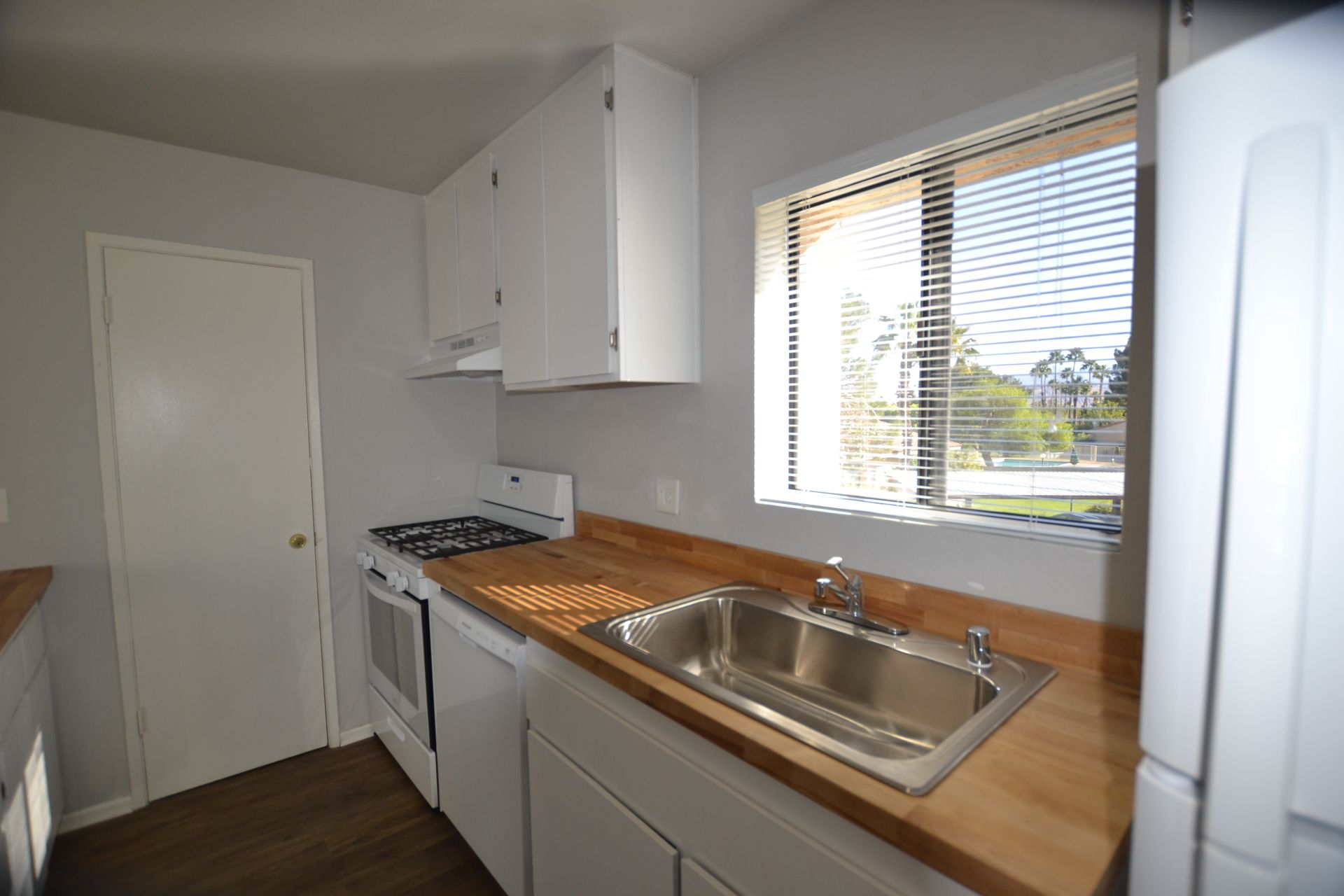 A kitchen with a sink and stove and a window
