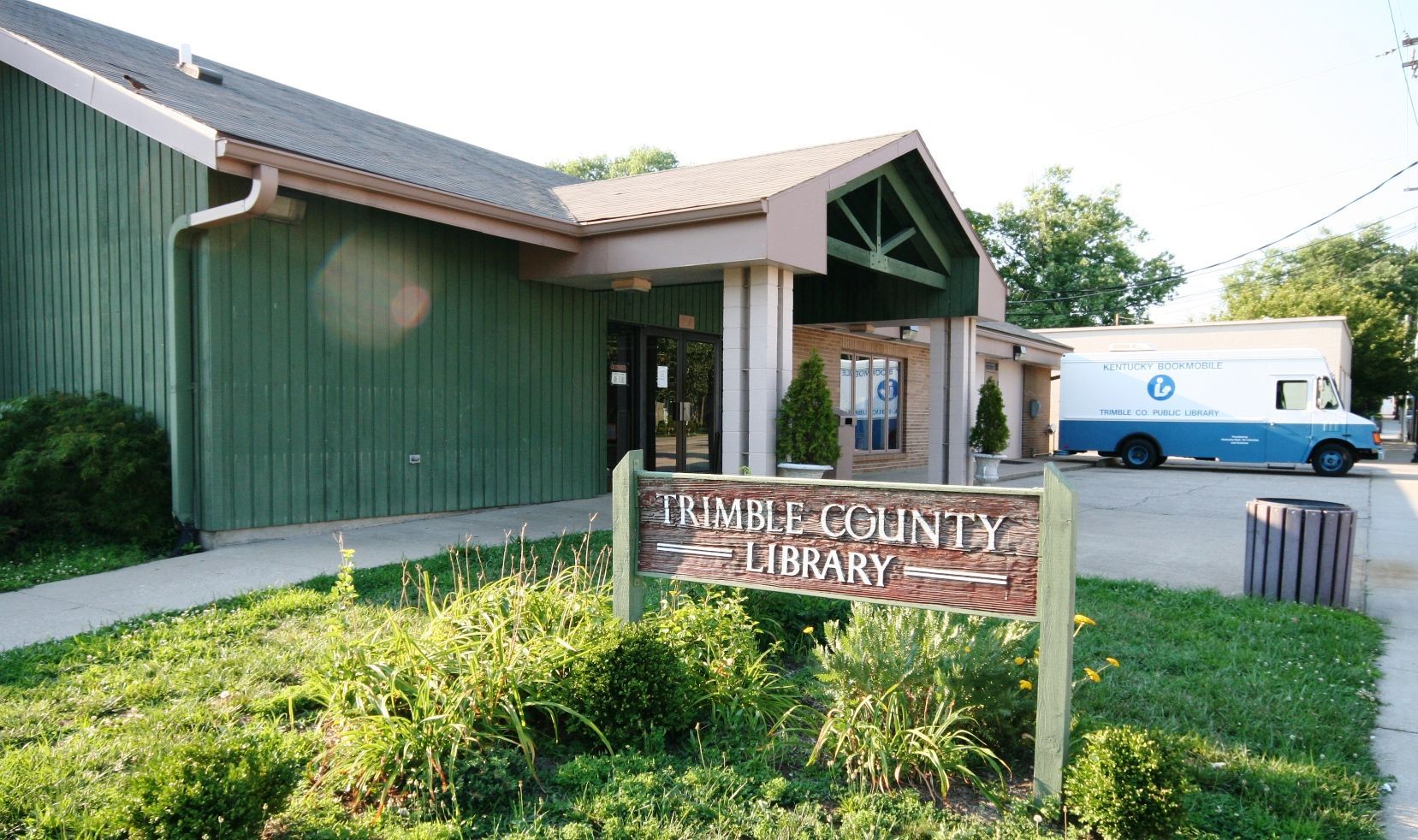 a green-walled building with a sign naming it 'trimble county library'