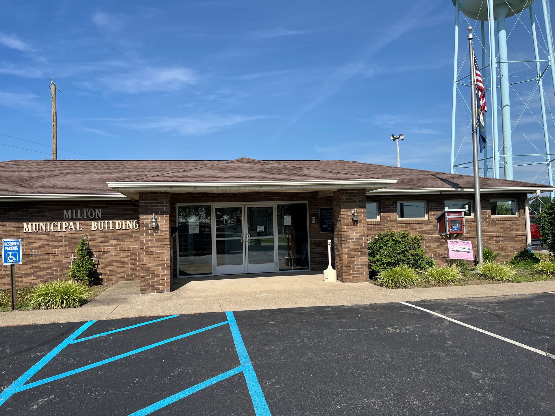 The milton municipal building with a flag on the pole in front.