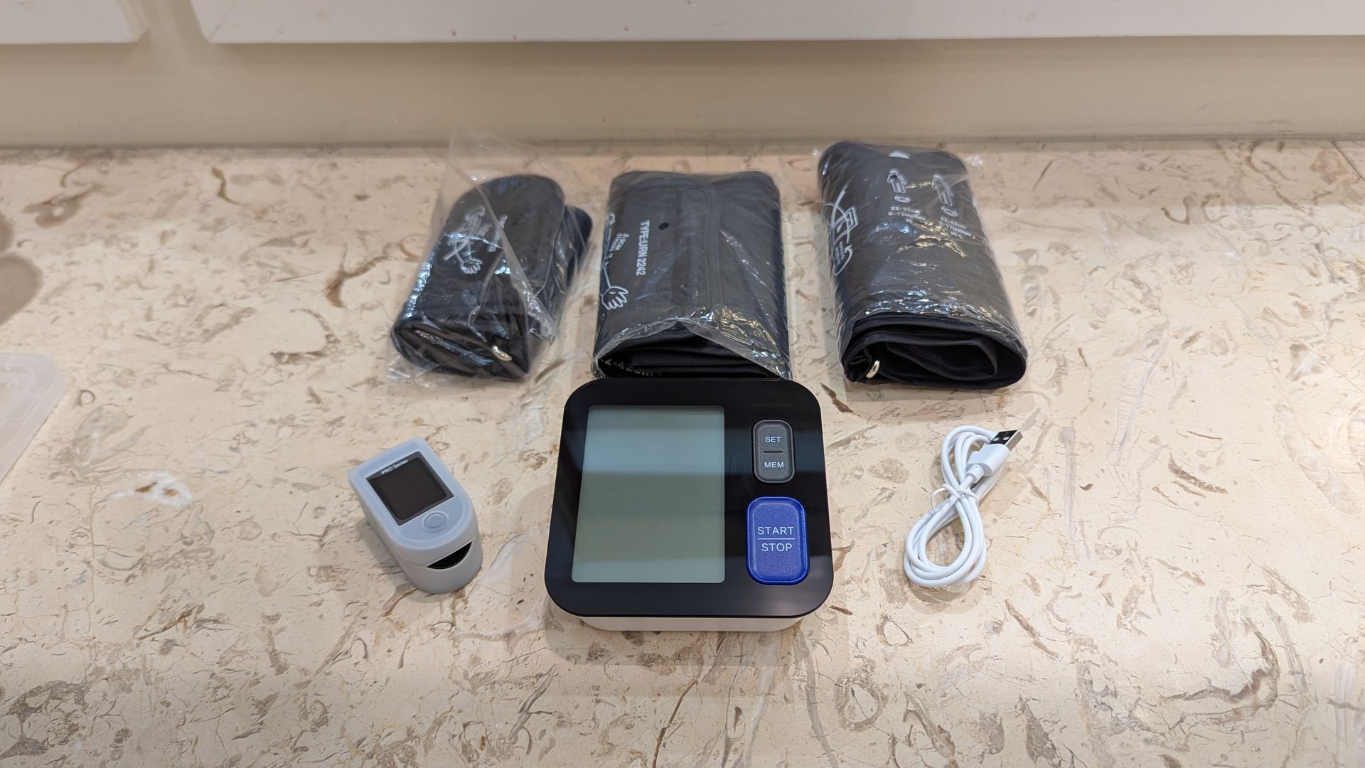 A blood pressure monitor kit with three cuffs of different sizes.