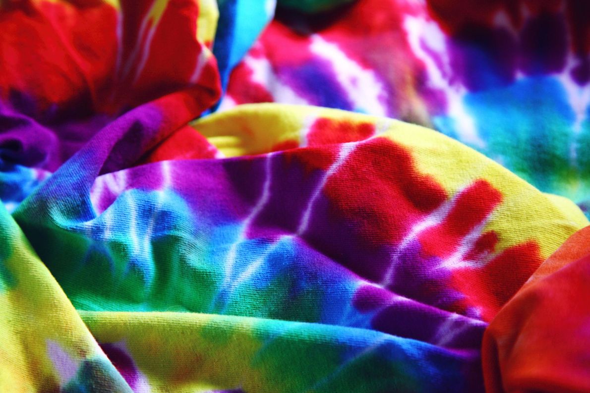 Close-up of rainbow tie-dye fabric with bright red, yellow, green, blue, and purple folds