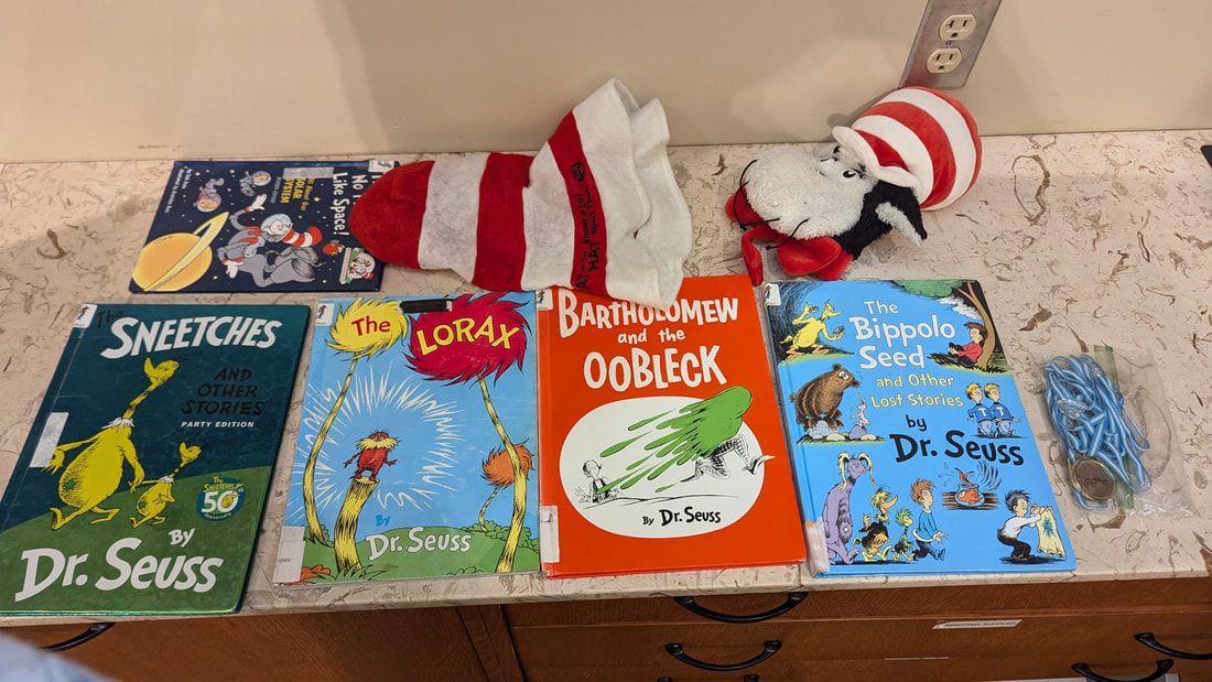 A collection of dr. seuss books including a wearable hat