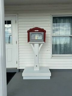A little free library is sitting on the porch of a church.