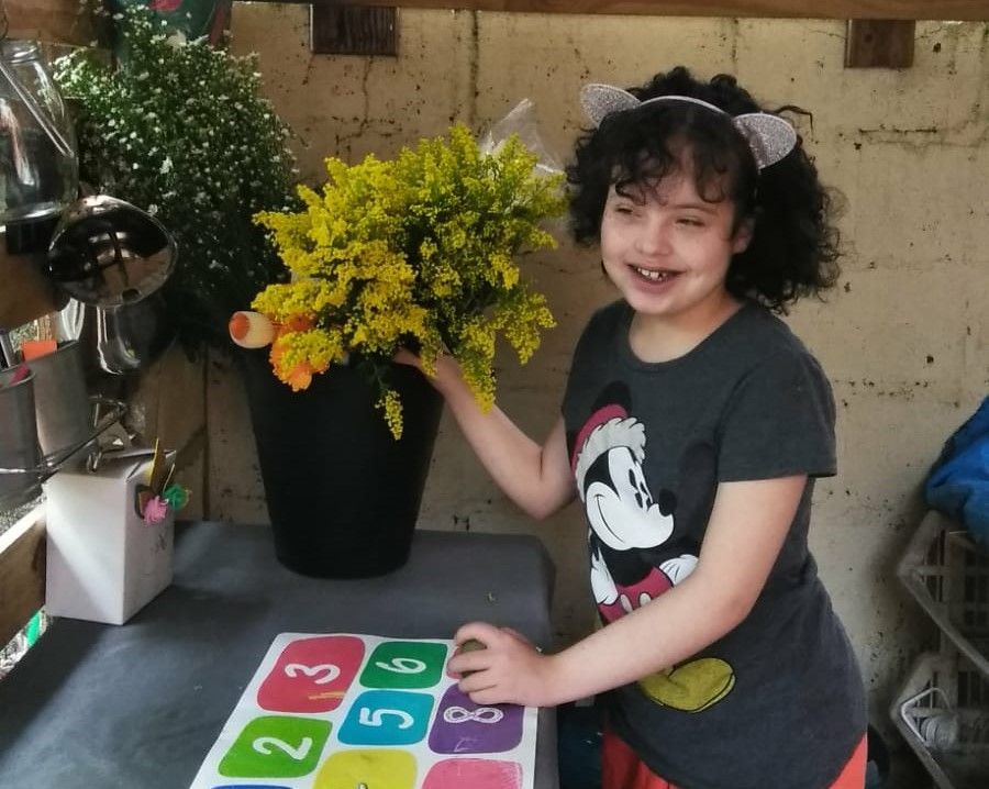 Girl with down syndrome next to flowers