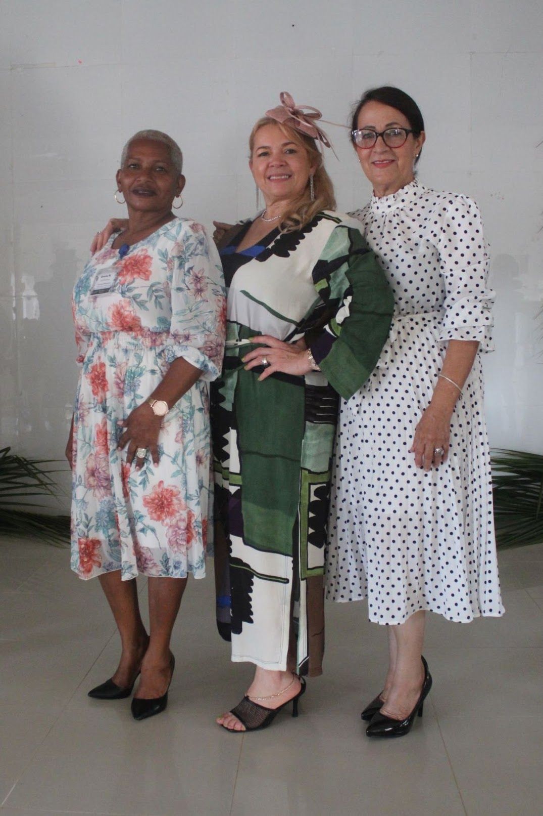 Three women in polka dot dresses are posing for a picture.