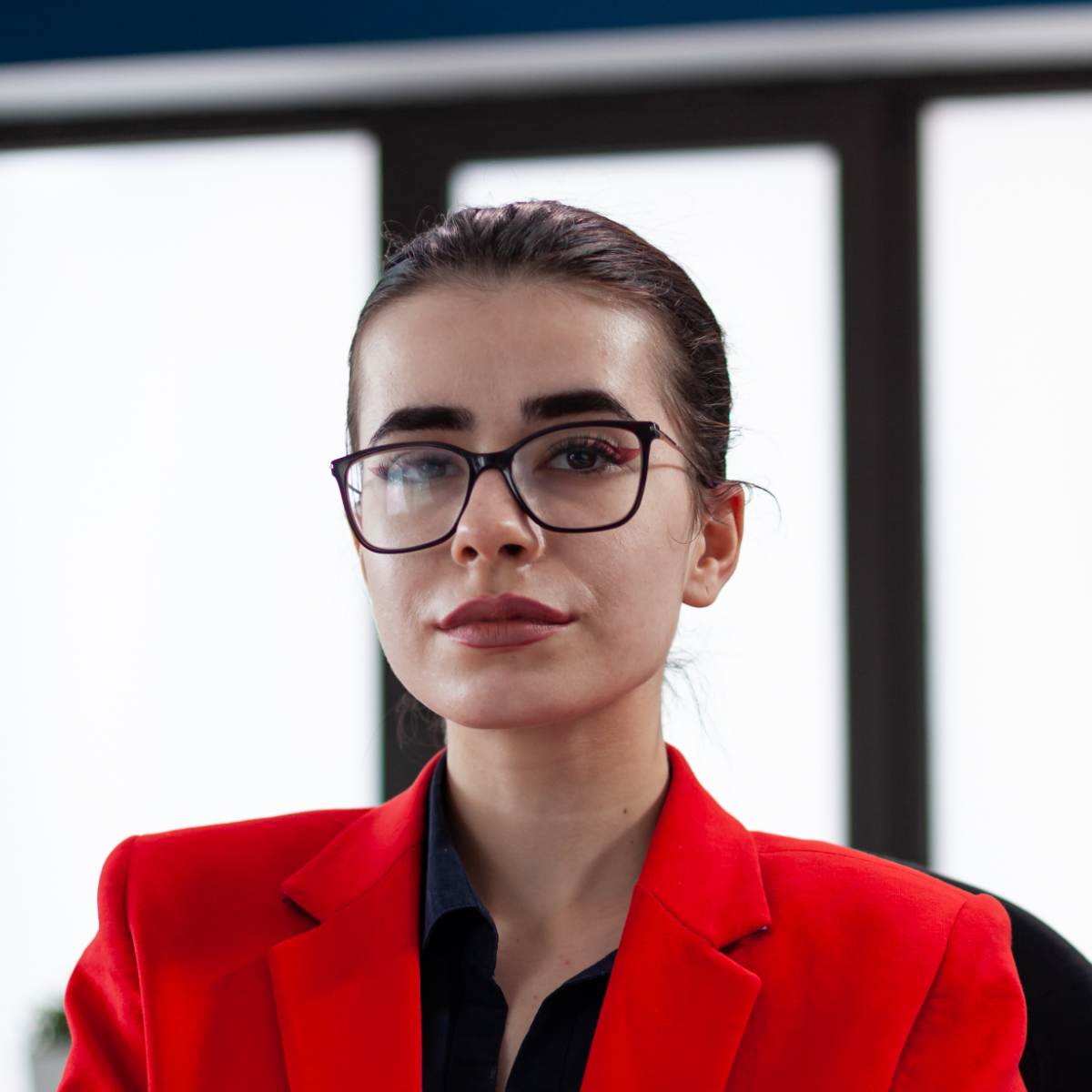 A woman wearing glasses and a red jacket