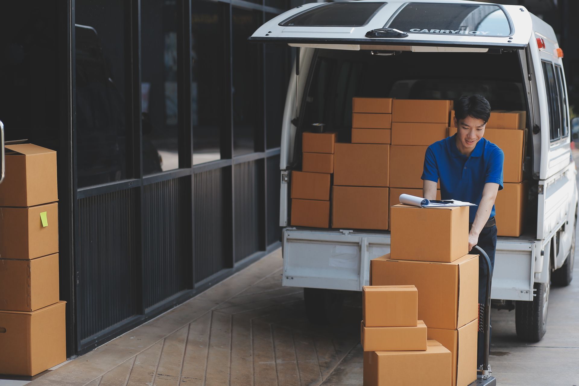A delivery man is loading boxes into the back of a van.