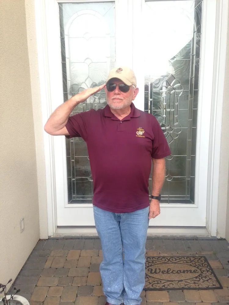 A man saluting in front of a welcome mat
