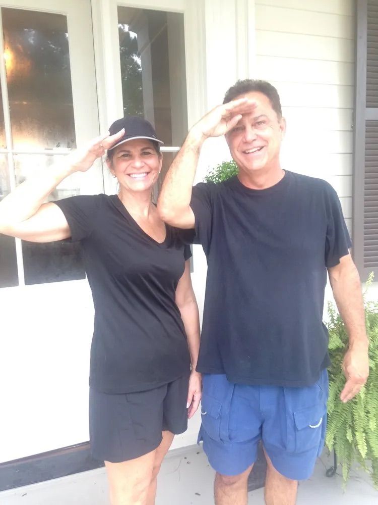 A man and a woman are posing for a picture on a porch