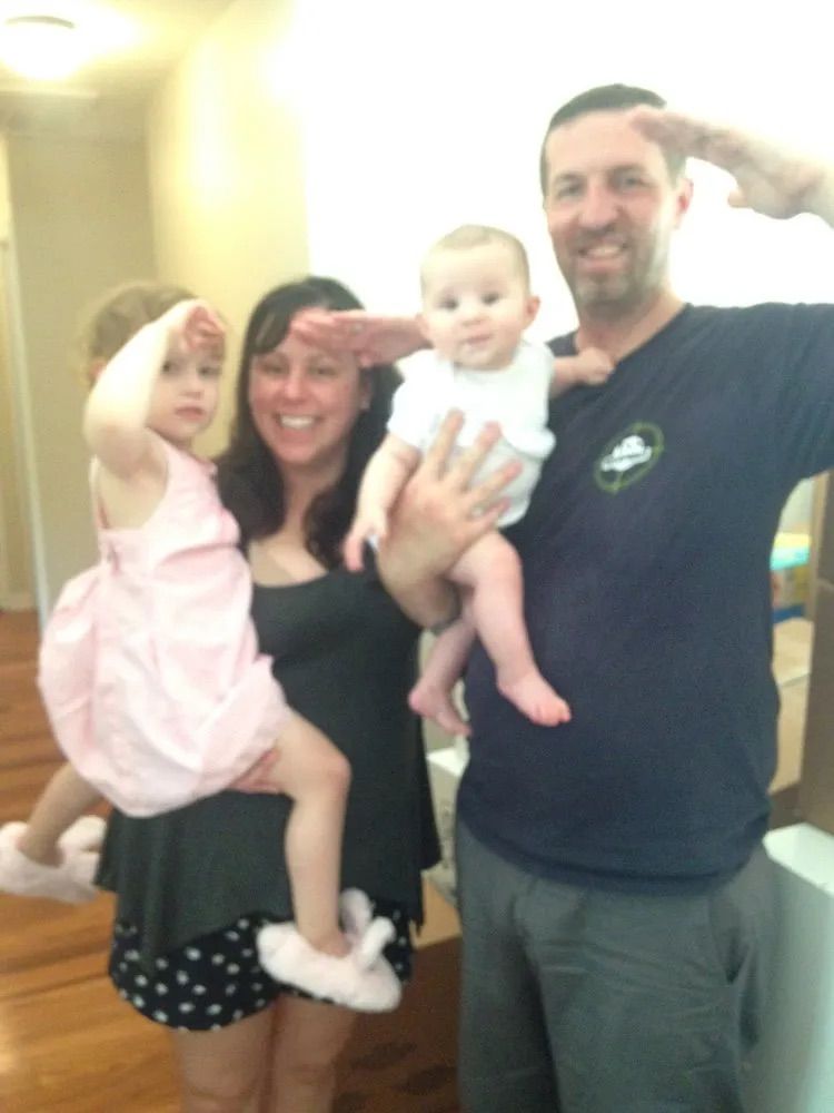 A man in a nike shirt is holding a baby