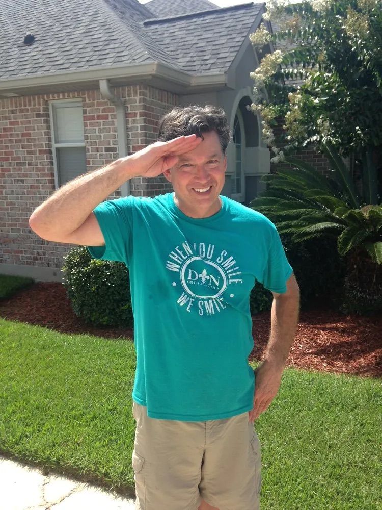 A man wearing a green shirt that says walk on smile