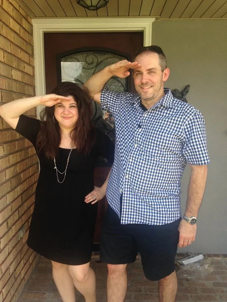A man and a woman are standing next to each other on a porch.