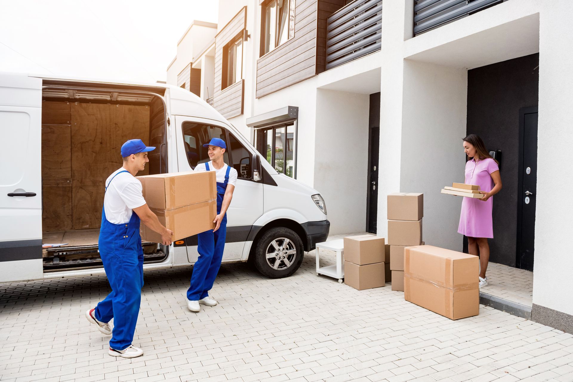 A group of movers are loading boxes into a van.