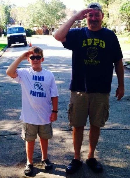 A man wearing a lupo shirt salutes a boy wearing a football shirt