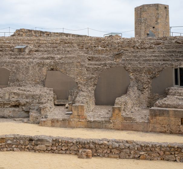 Las ruinas de un edificio antiguo con una torre al fondo