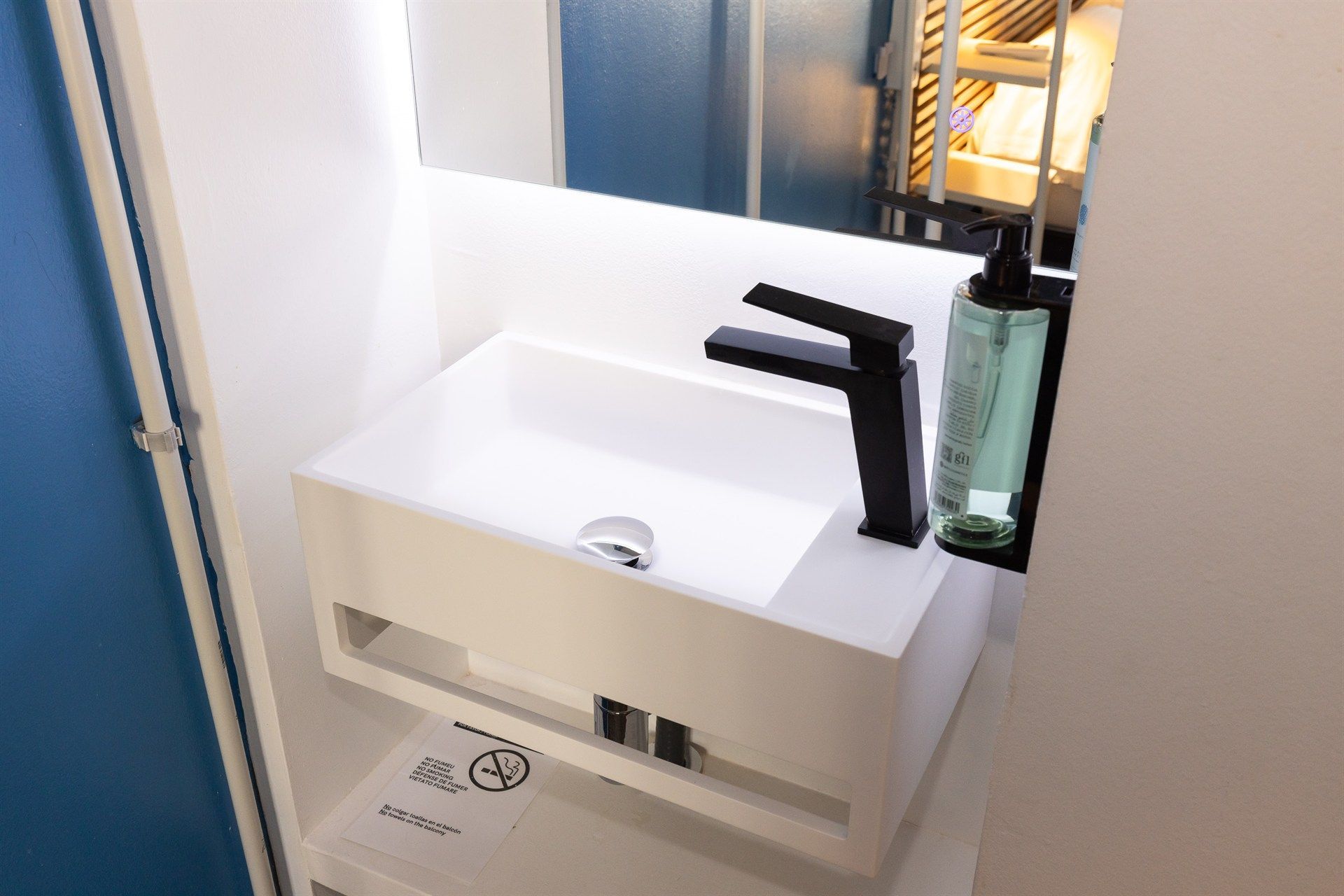 Un lavabo de baño con grifo negro y espejo.
