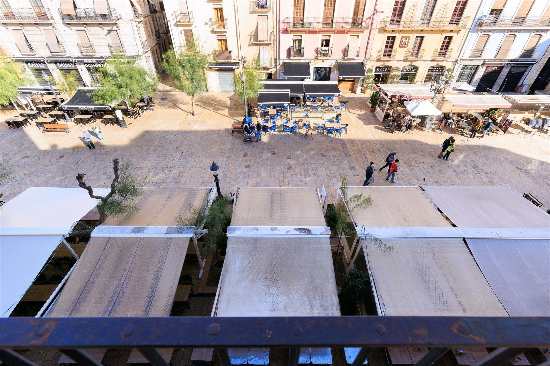 Una vista de una ciudad desde un balcón con una hilera de toldos.