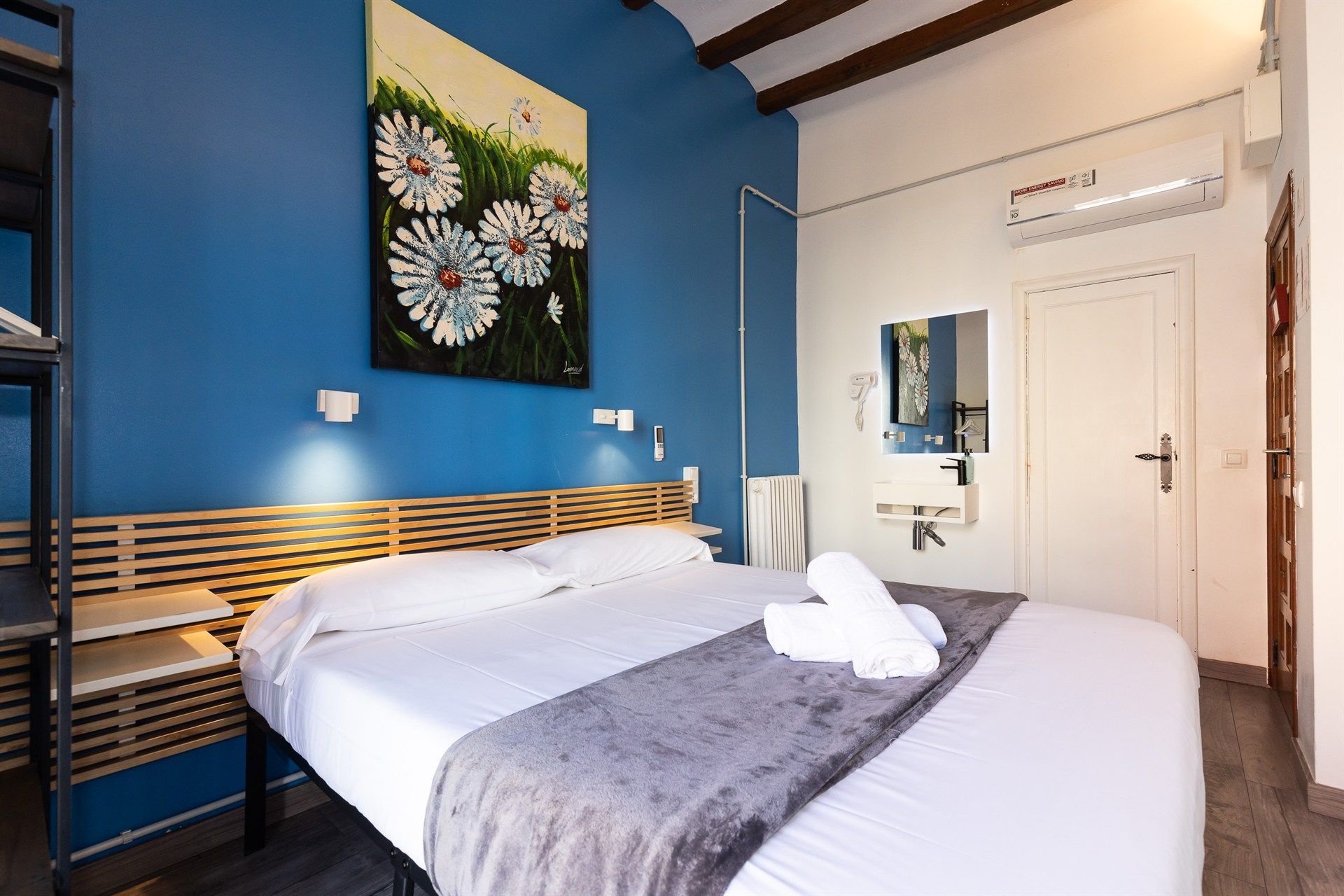 Un dormitorio con una cama y un cuadro en la pared.